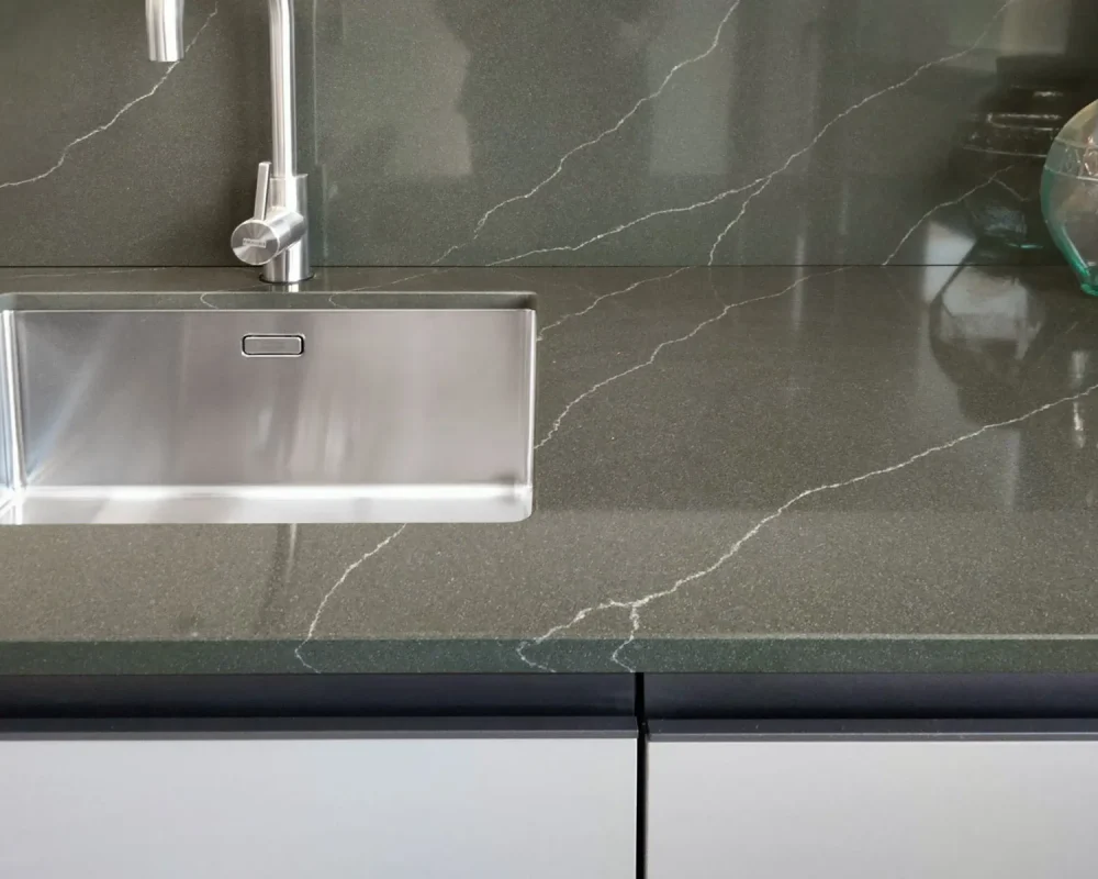 stone-italiana-cosmolite-materiale-ecosostenibile-cucina-venantis-green-artemis-top-paraschizzi-verde-vena-passante-dettaglio-con-lavandino.jpg