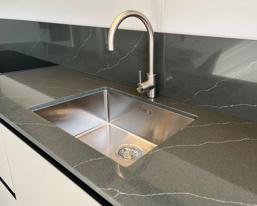 stone-italiana-cosmolite-materiale-ecosotenibile-cucina-venantis-green-artemis-top-paraschizzi-verde-vena-passante-dettaglio-con-lavandino-piano-induzione.jpg